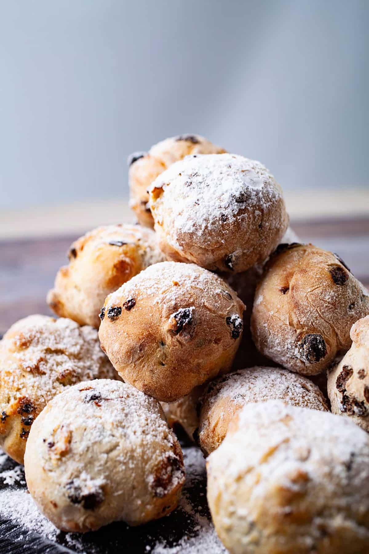 A tower of raisin filled Zeppole doughnuts topped with powdered sugar.