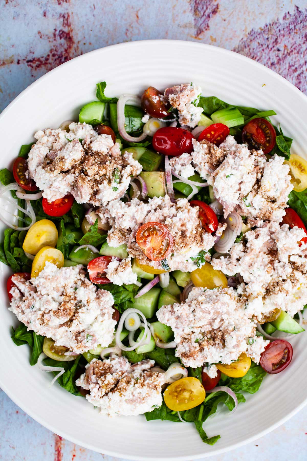 A large serving plate with a tuna cucumber salad with ricotta cheese.