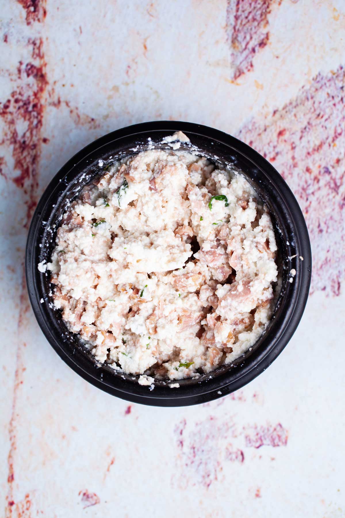 A small bowl with a tuna and ricotta cheese mixture.