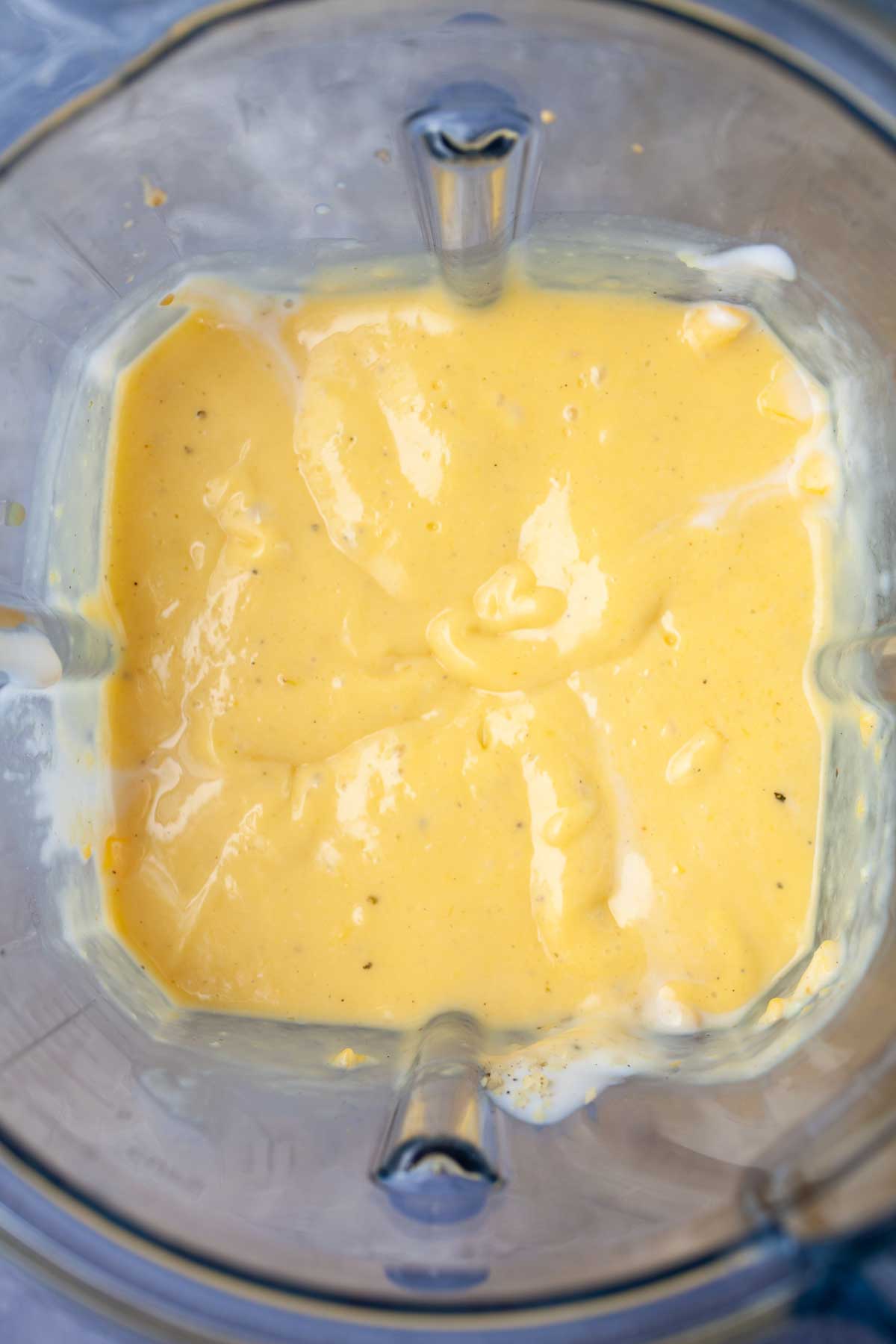 Creamy vegan mango lassi in a blender.