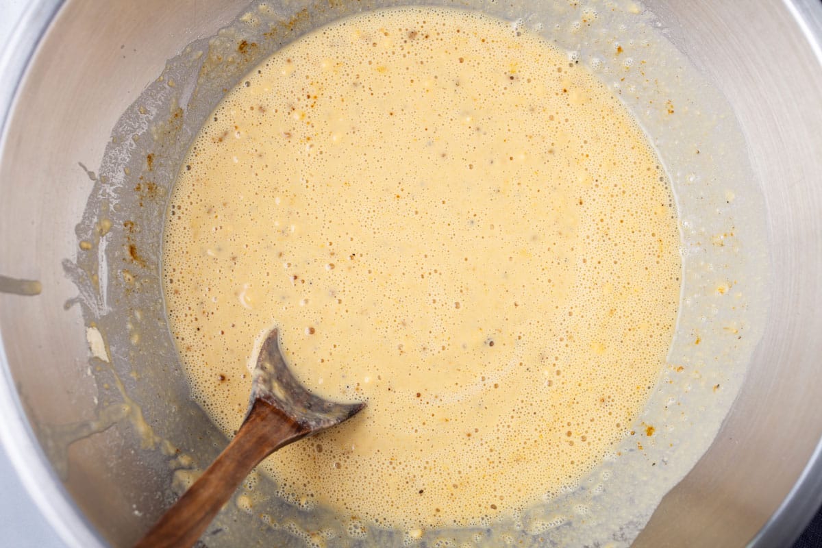 A wooden spoon resting in a seasoned batter.