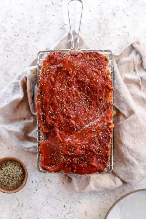 an overhead shot of ground bison meatloaf on a metal wire rack on top of a napkin.