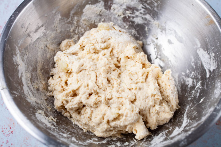 A stainless steel bowl filled with white dough.