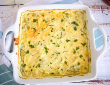 Baked zucchini with a cheesy topping in a baking sheet.