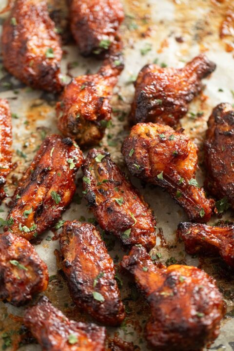 BBQ baked chicken wings on a baking sheet.