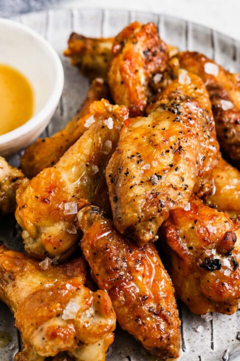 a close up shot of salt and vinegar wings and the wings are topped with flaky salt.