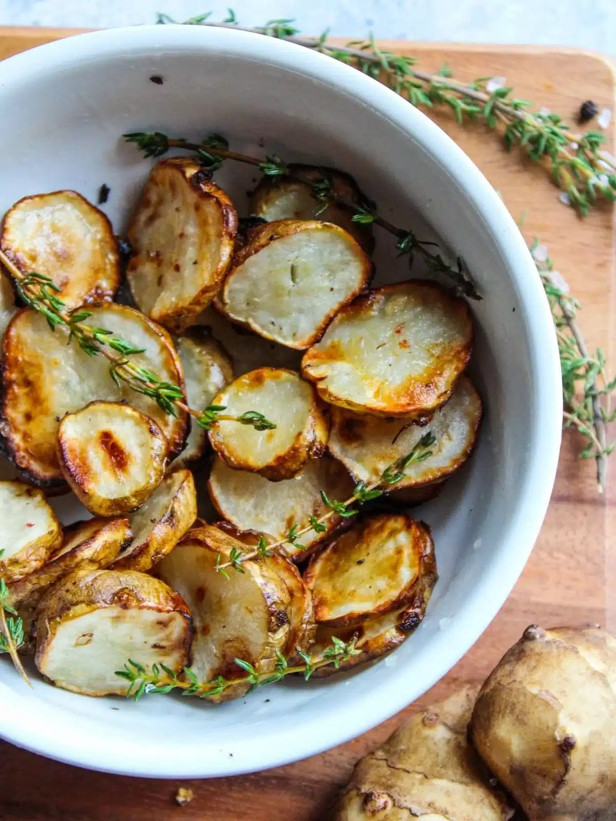 A bowl with roasted sunchokes with Thyme.