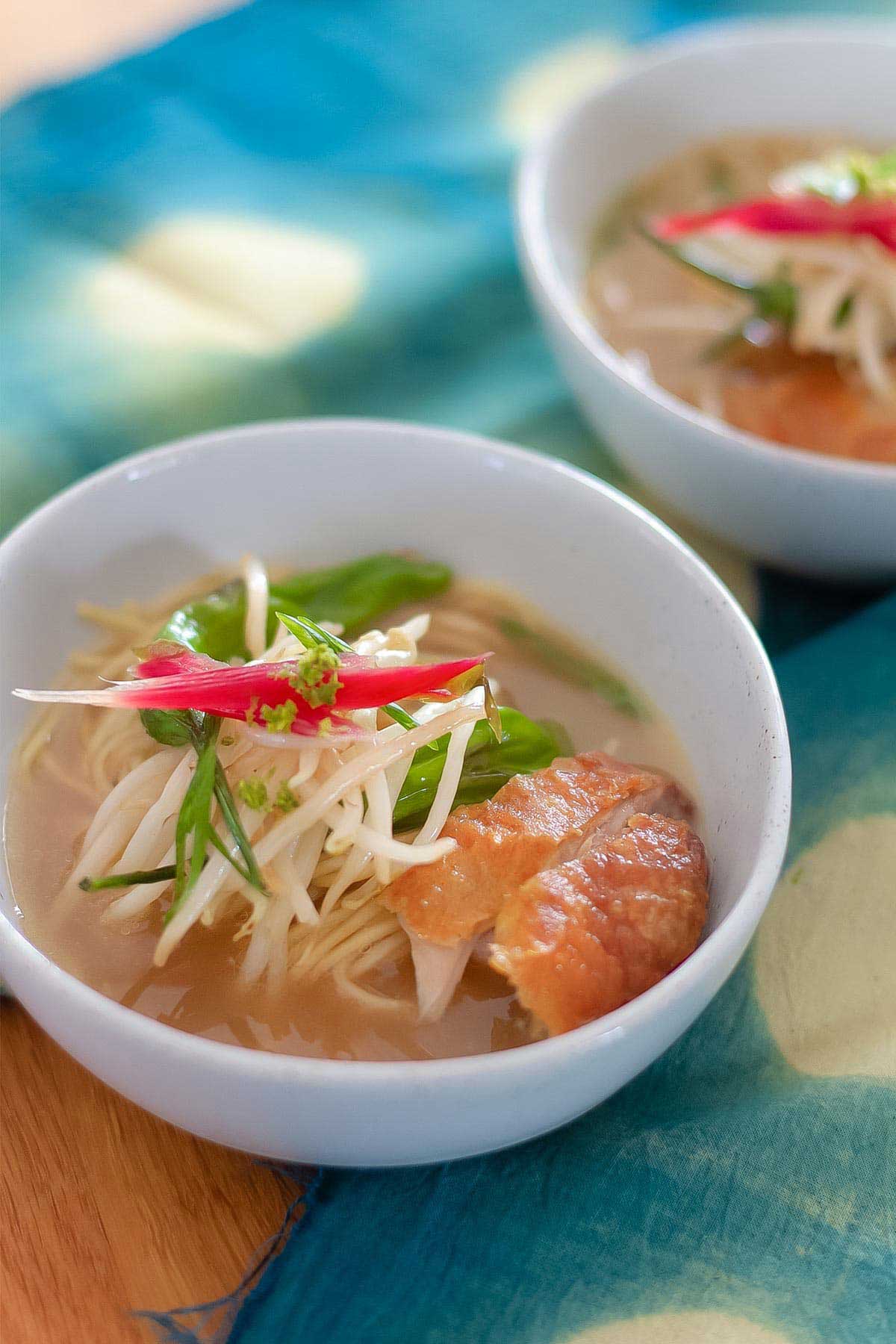 Ramen soup in a bowl topped with veggies.